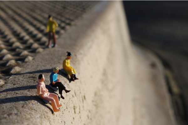 Figuren sitzen an einem Abgrund